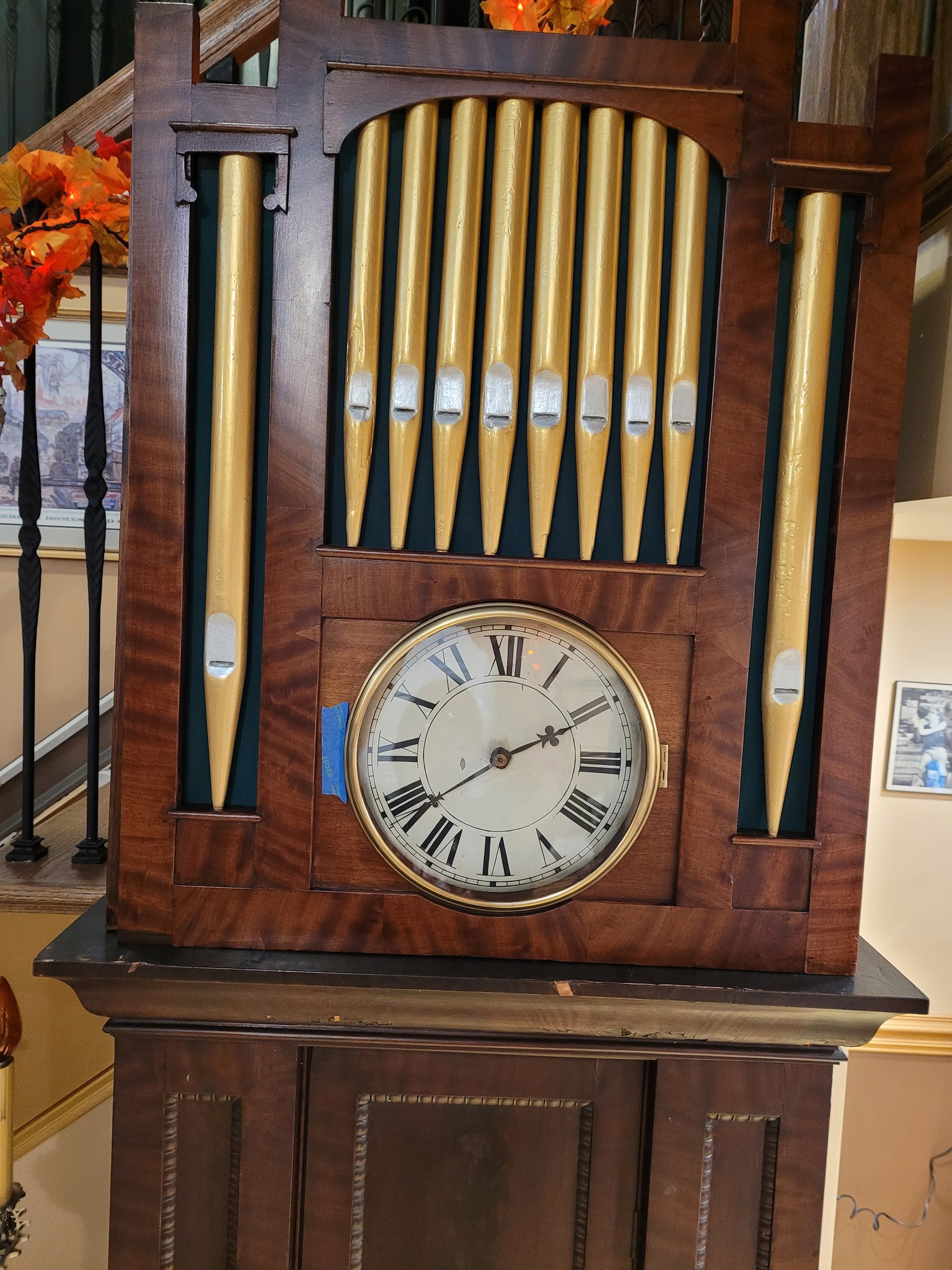 Village - Close up of the clock bonnet with decorative facade pipes ...
