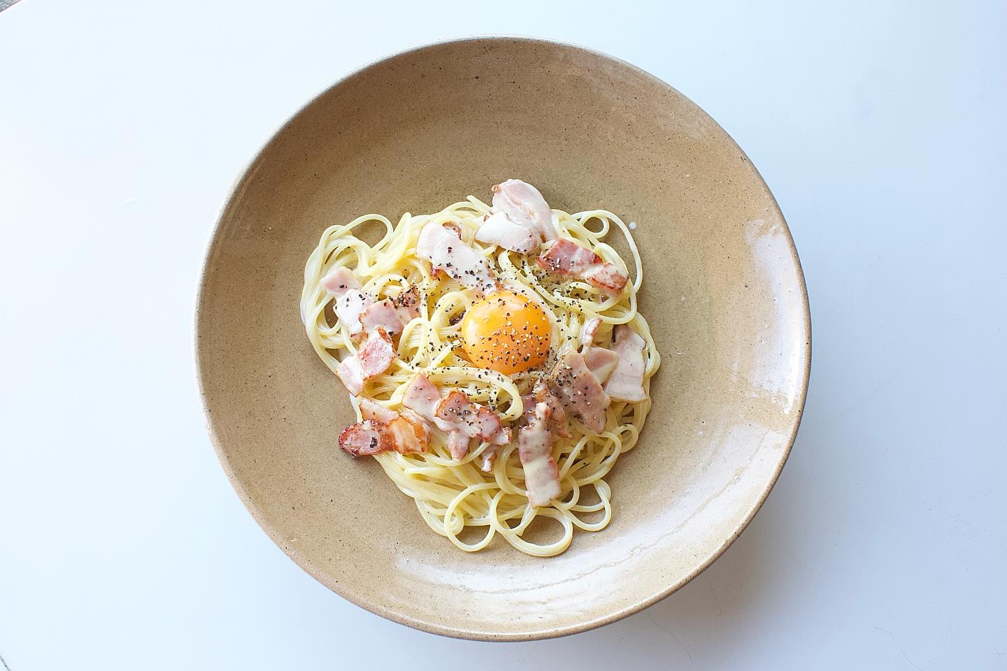 カルボナーラ」 暖色の27cmの皿。 手前作のパスタと共に