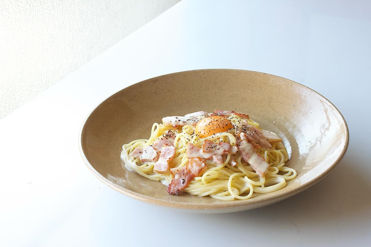 カルボナーラ」 暖色の27cmの皿。 手前作のパスタと共に