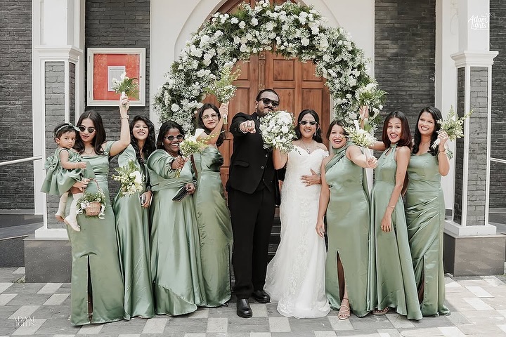 Bridesmaids Steal the Show in Stunning Sage Green Satin Dresses at Dreamy Wedding!” The bridesmaids' outfits are elegant, floor-length satin dresses in a soft sage green color. Each dress features a unique