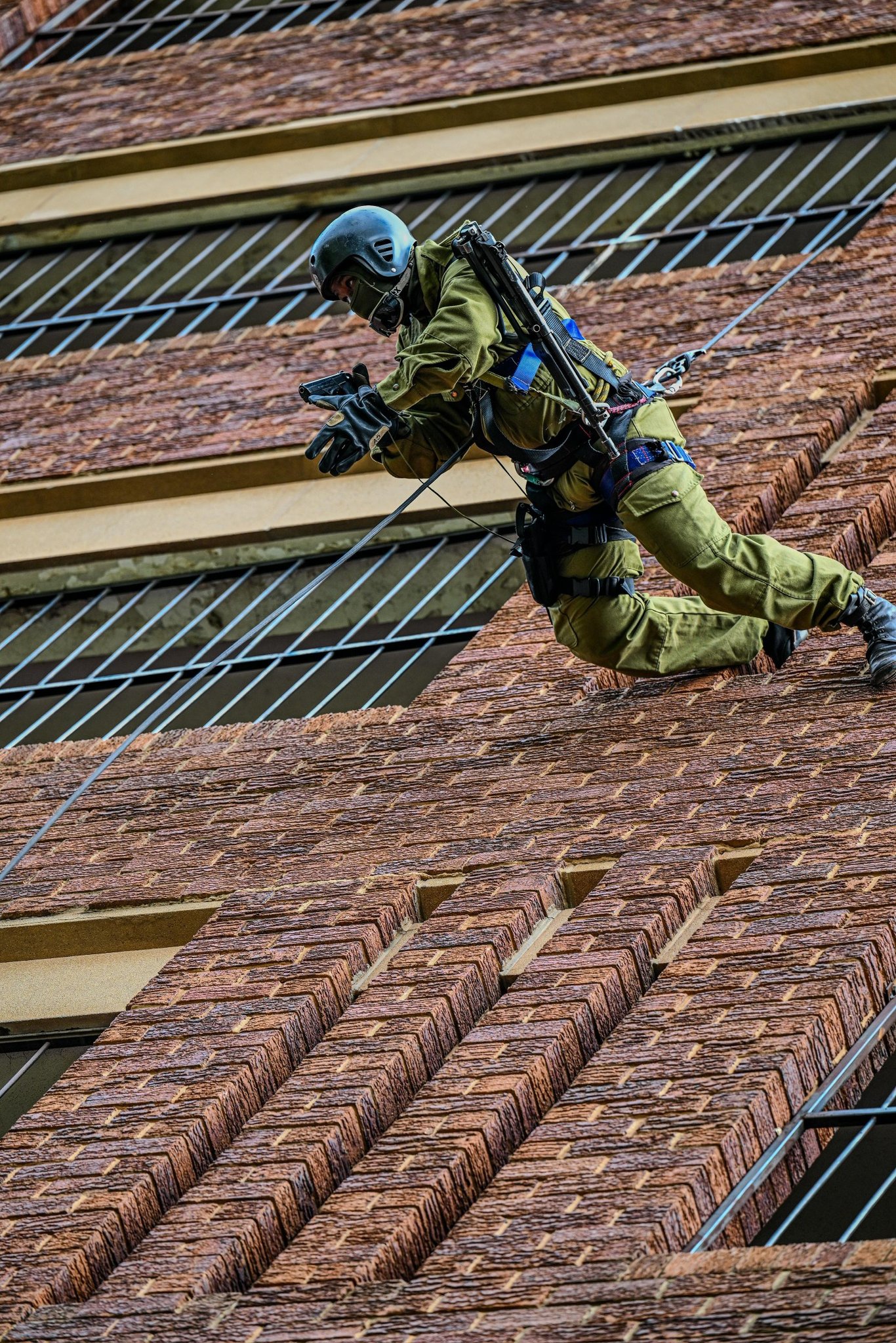 SA - A fast-roper moves down the structure equipped with both a pistol ...