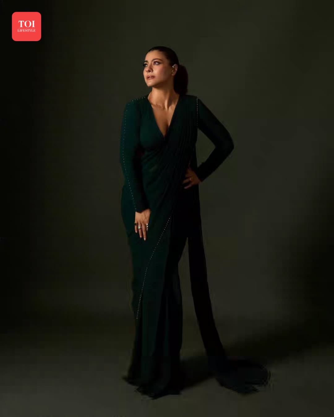 kajol green dress wowed in a bottle-green fusion drape at a recent award show, wearing a pre-stitched saree by Qbik with metallic beadwork. #Kajol #FusionFashion #AwardShowLook kajol ddlj outfits