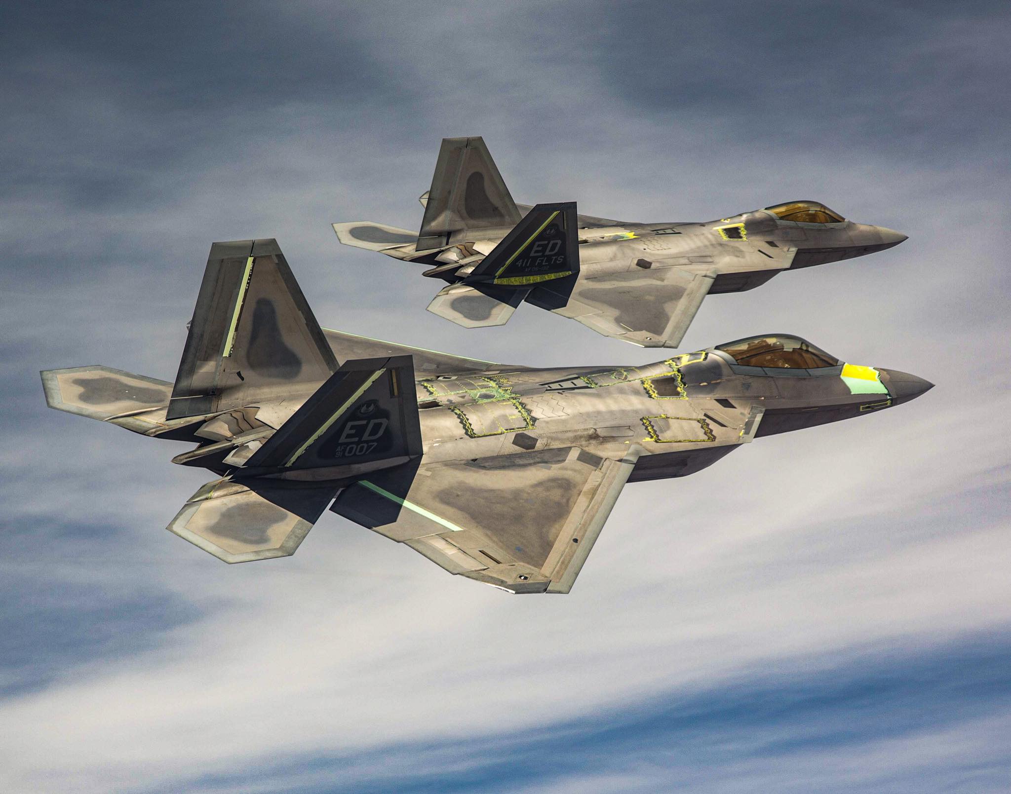 World - Two F-22 Raptors from the 411th Flight Test Squadron fly above ...