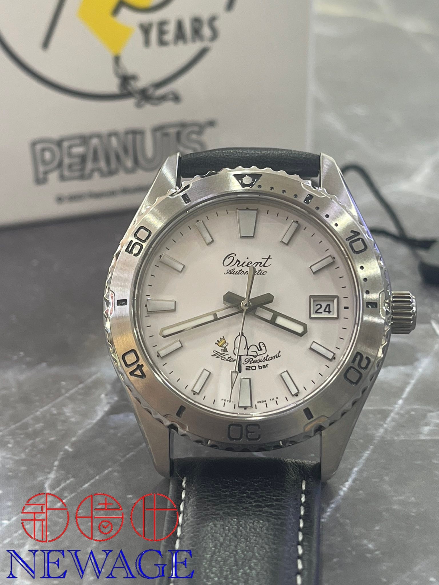 ORIENT X PEANUTS RA-AC0Q08S 腕錶的12 點鐘位置印有東方錶的原創草書 