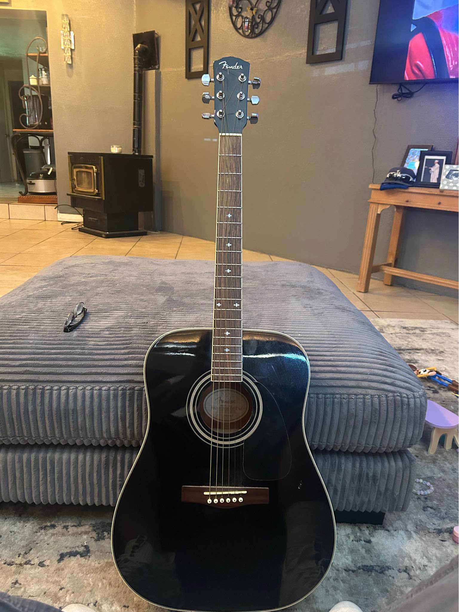 Sleek black acoustic guitar. Fender DG-16 model. Guitar has six