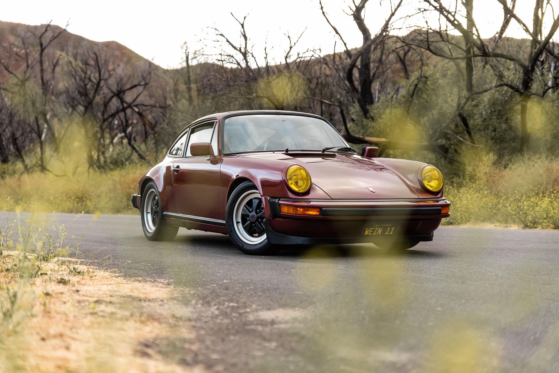 Vintage metallic red Porsche with yellow fog lights