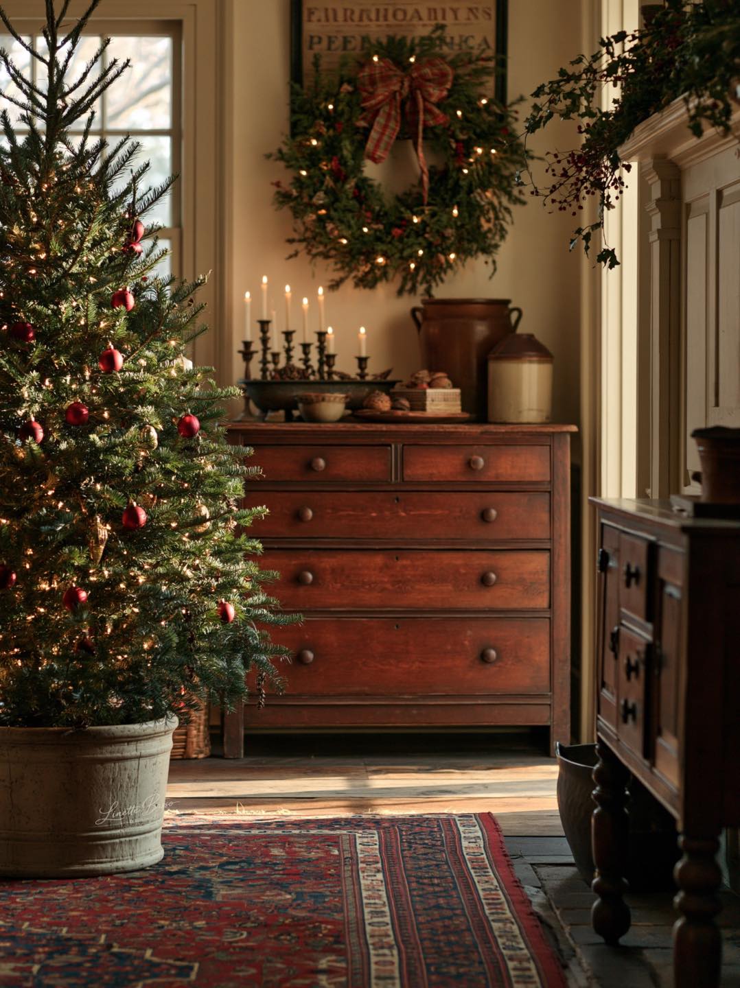 Decorating antique dresser for Christmas with greenery and decor