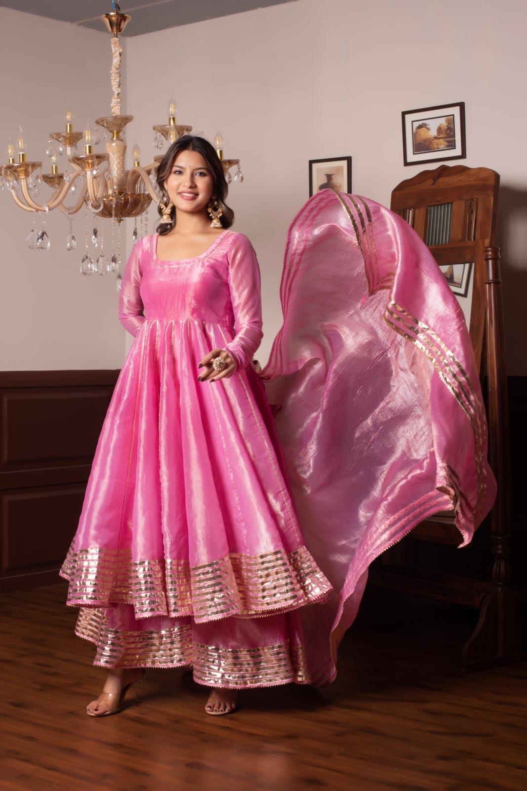 Vibrant pink cocktail dress is made of a textured, silk-like fabric. This fit and flare garment has thin spaghetti straps and a deep V-neckline. A large fabric rosette is attached to the