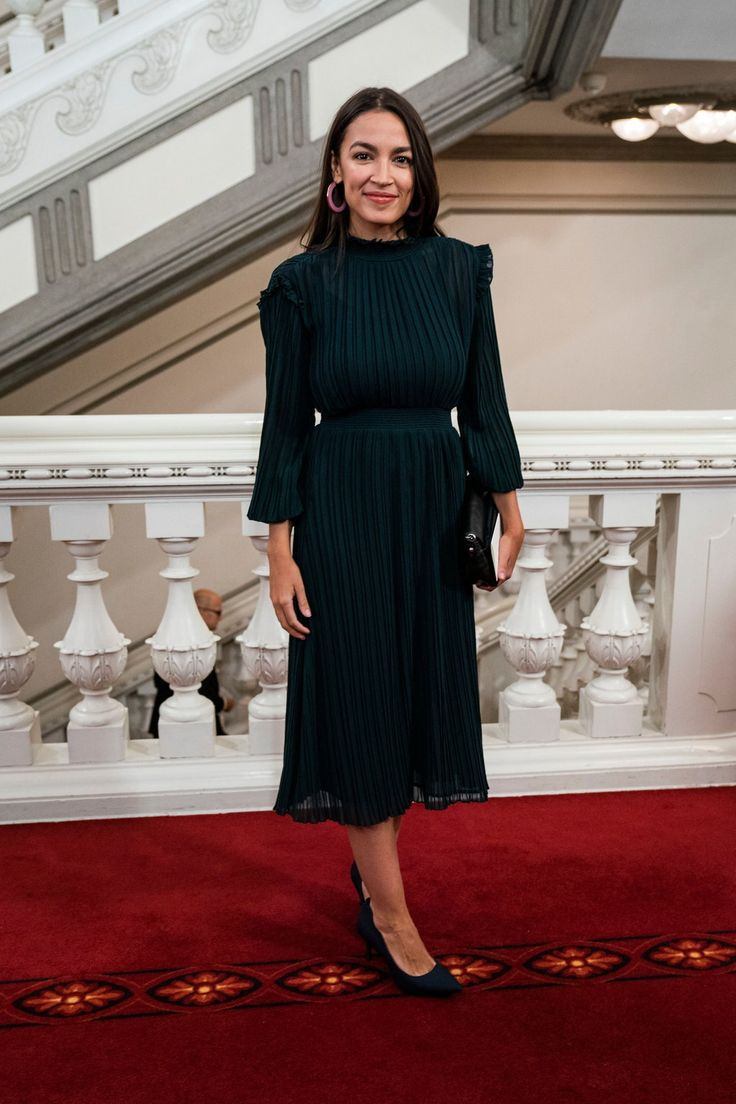 alexandria ocasio cortez black dress A mural depicting the face of Rep. Ocasio-Cortez is displayed on a wall in the Lower East Side neighborhood of Manhattan in New York City. Street artist Lexi Bella painted the Style:EE02370BK Stacees Cowl Neck Tea-Length Always @ Nine West