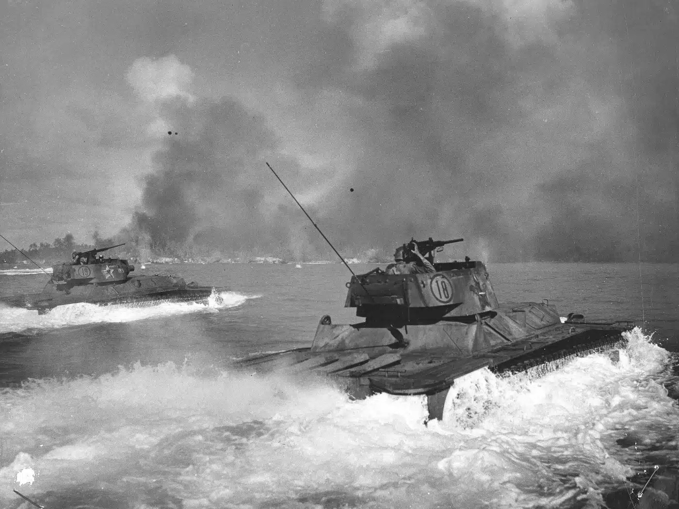 The War - Two amphibious tanks surge toward Peleliu’s shore, cutting ...