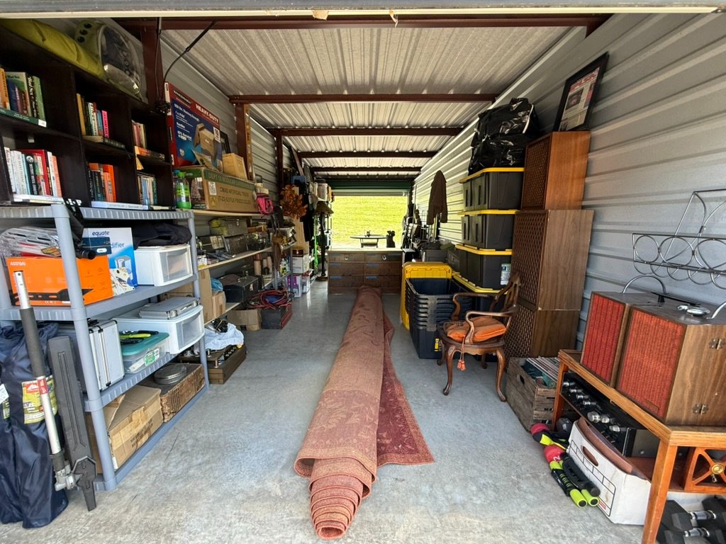 Garage sale with kitchen table, queen bed, and clothing in Erwin