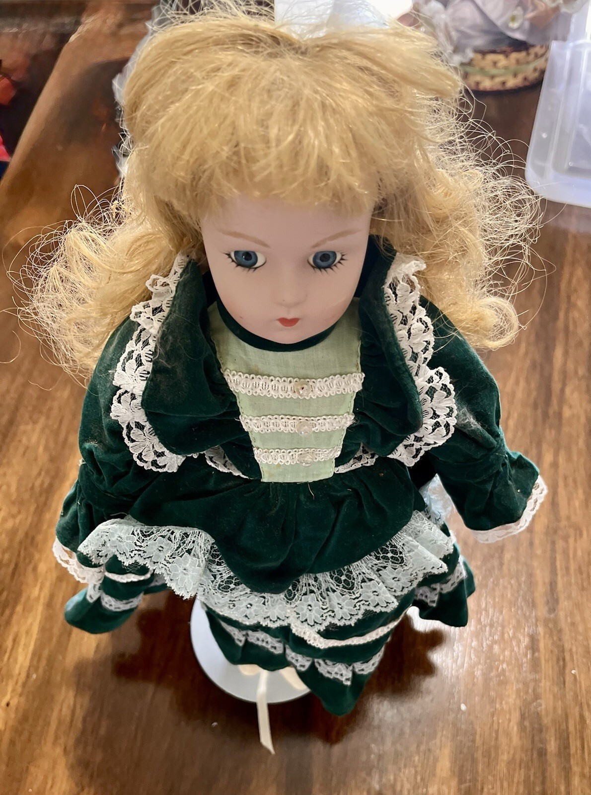 porcelain doll with green velvet dress Vintage 16-inch collector doll. She features blonde curly hair, brilliant blue eyes, and wears a striking, layered emerald adorned intricate white lace trim and faux pearl details pearl bling