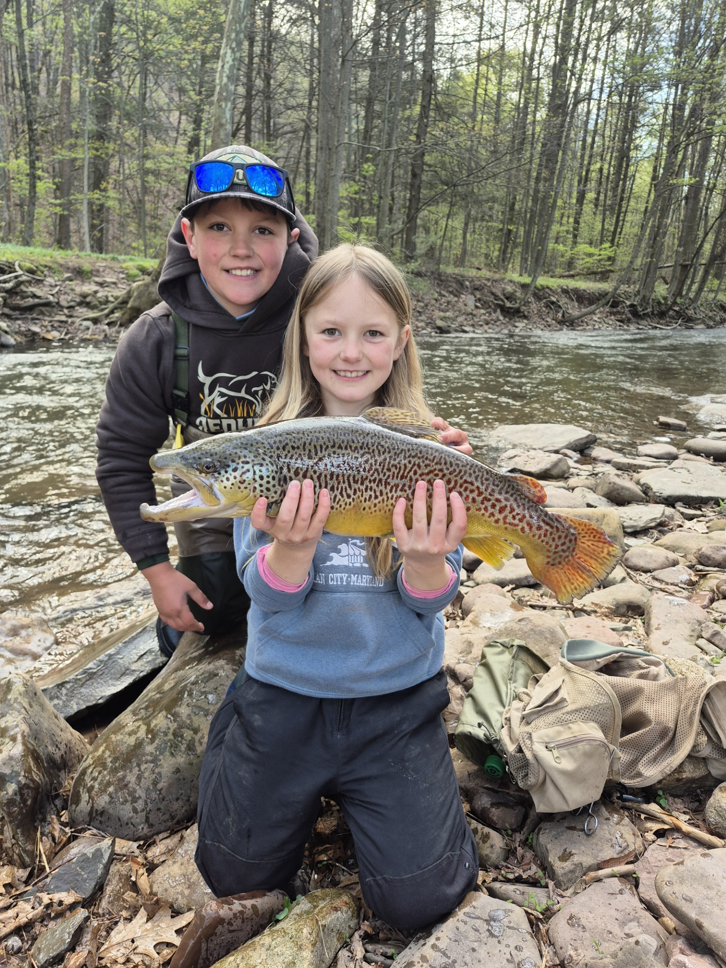 Young girl catches big brown trout with brother