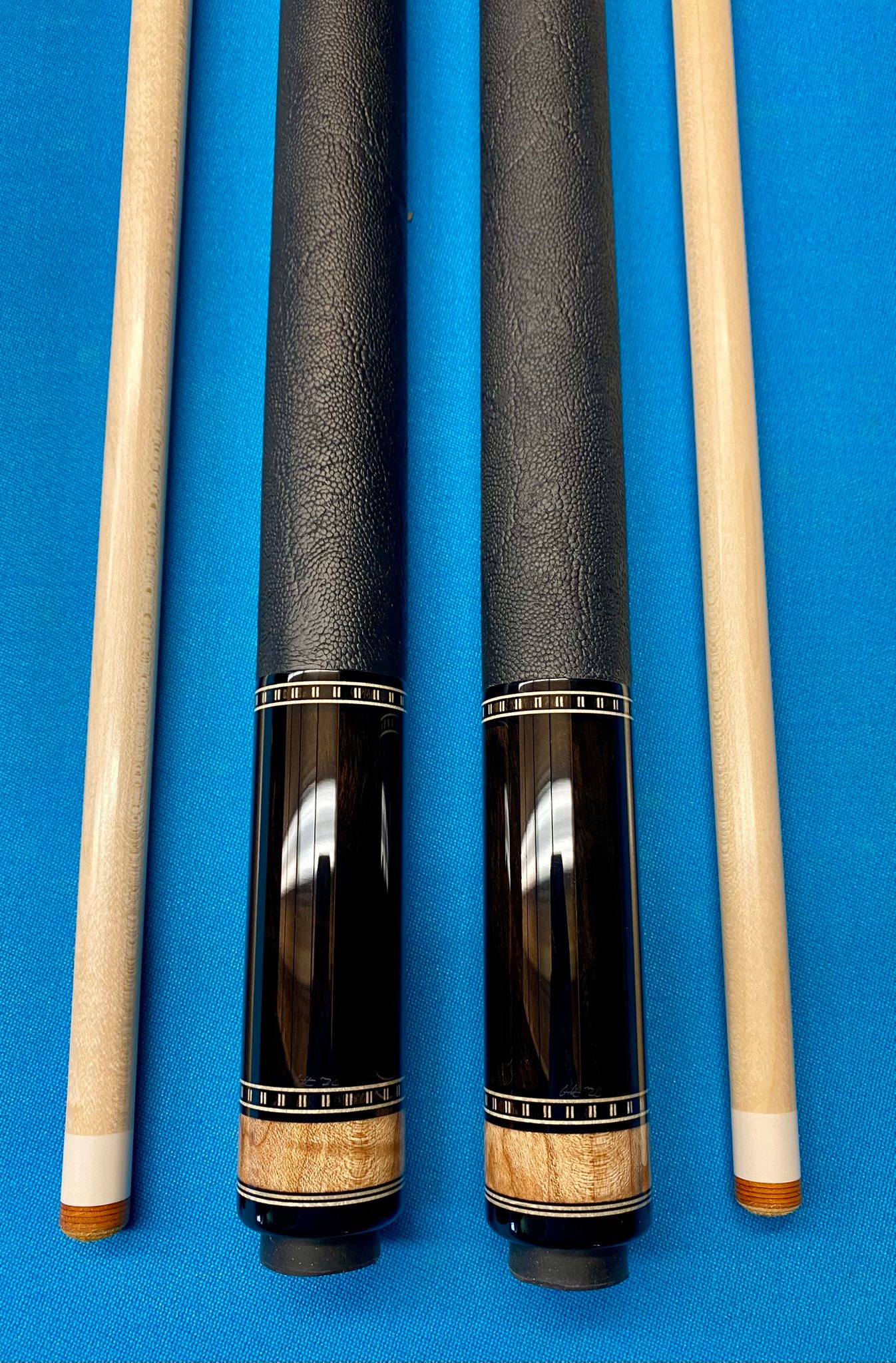 Twin cues heading for Japan. Maple Burl points into Indian Ebony.