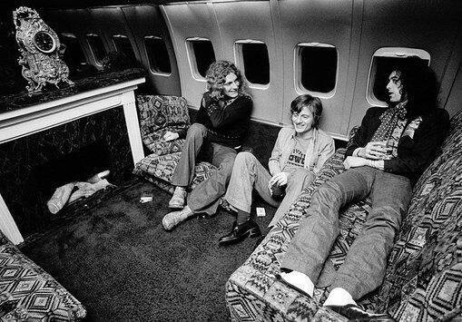 Led Zeppelin hanging out in front of their fireplace in the