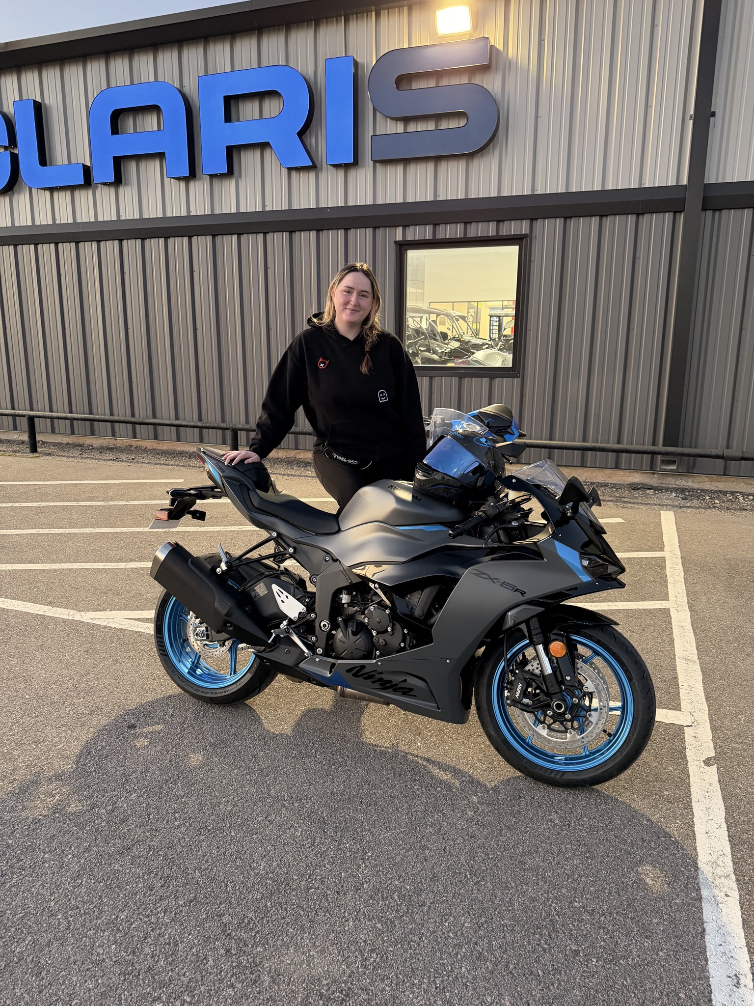 Skyla just picked up her DREAM bike — a gray and blue Kawasaki