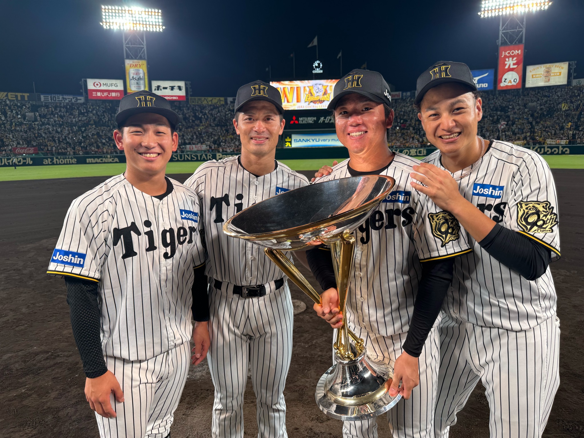 優勝トロフィーを掲げる選手たちです！ グラウンドで歓喜を分かち合う
