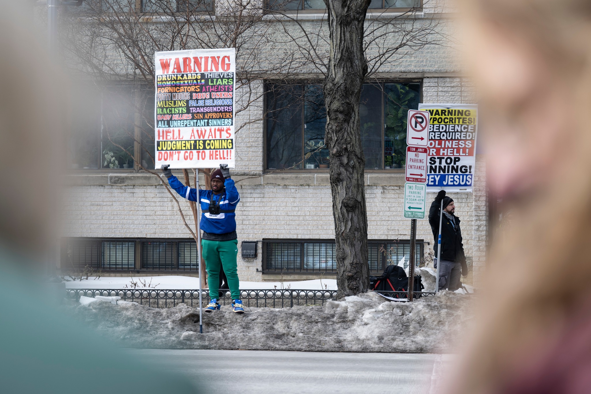 Mizzima - A small group of religious protesters hold signs as people ...
