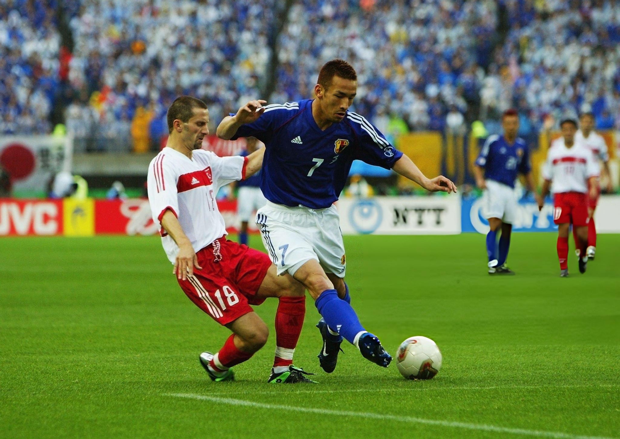Hidetoshi Nakata of Japan takes the ball past Ergun Penbe of