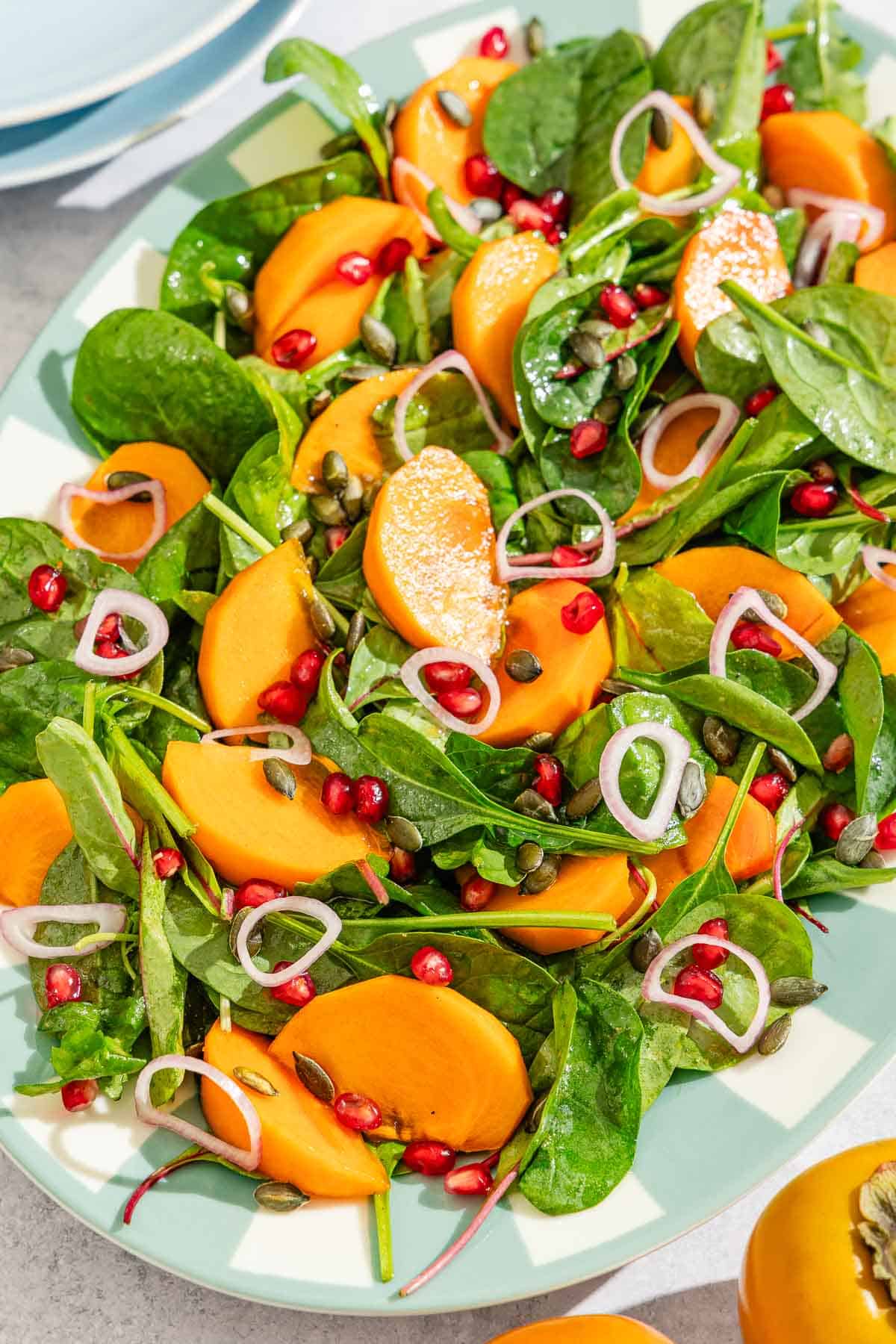 This persimmon salad with pumpkin seeds, and spiced apple cider vinaigrette is perfect for fall! https://themeddish.com/Persimmon-Salad