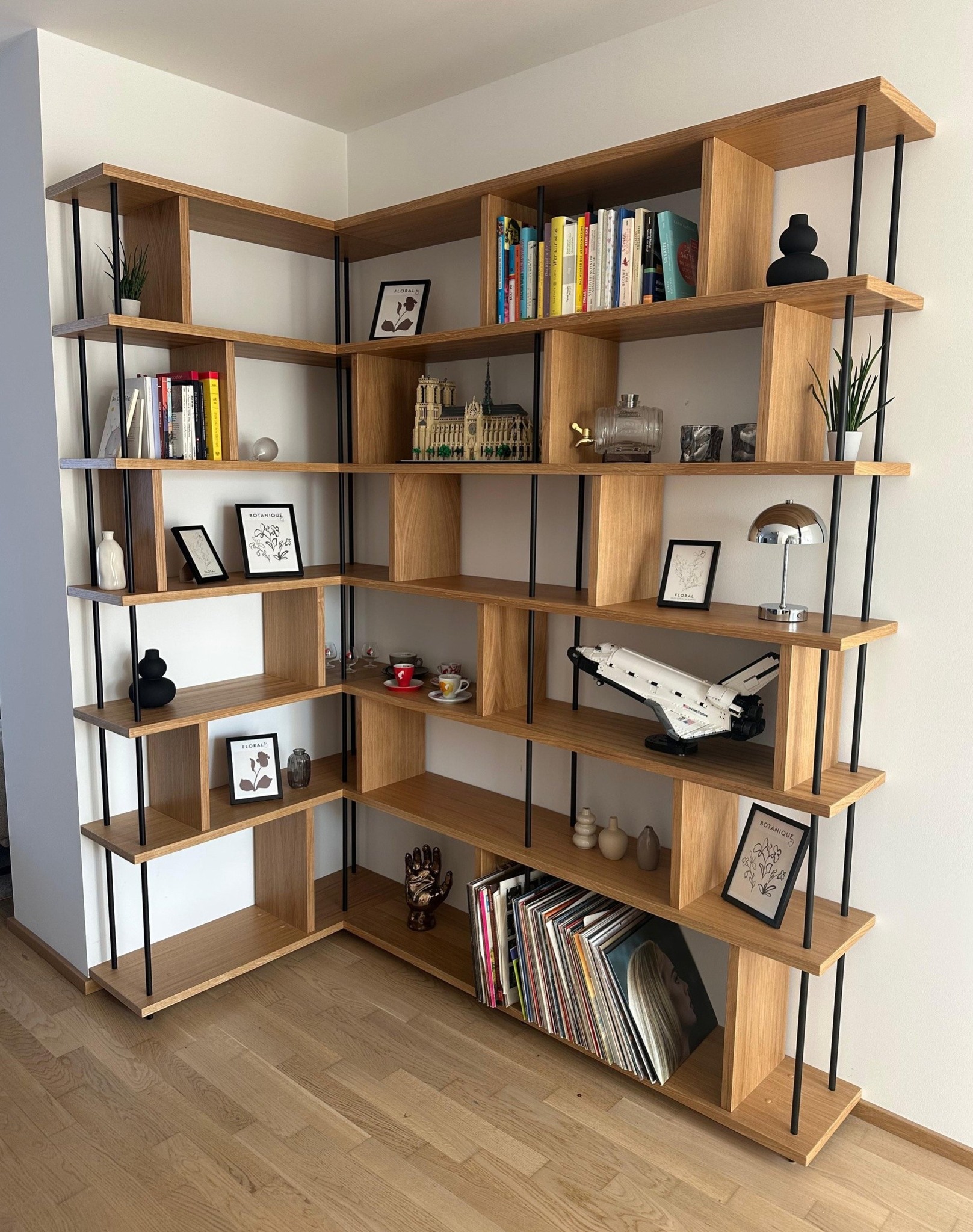 📚 Ecke mit Charakter! 🪵 Dieses maßgefertigte Eck-Bücherregal bringt nicht nur Ordnung ins Wohnzimmer, sondern ist auch ein echter Hingucker. Gefertigt aus edler furnierter Eiche, überzeugt das Regal durch eine offene Stollenkonstruktion