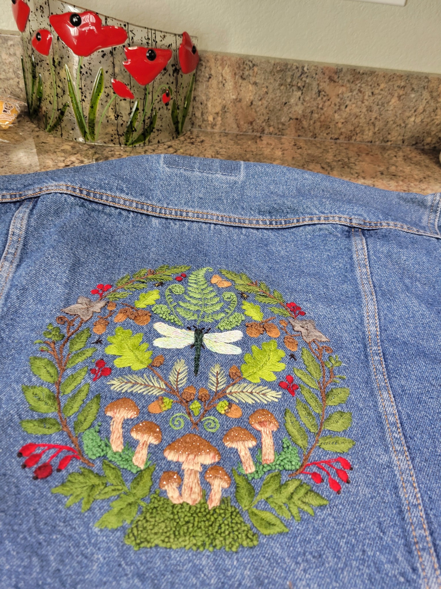 Hand-embroidered dragonfly and mushroom design on jean jacket