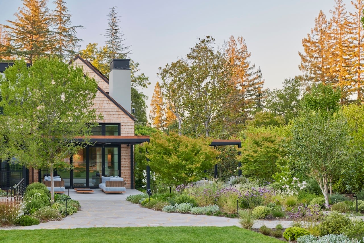 A romantic landscape surrounds this new modern shingled home. A 