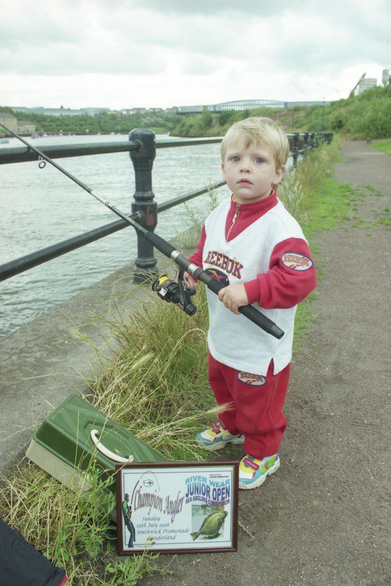 boy holding fishing reel and rodreel All In One Kid Friendly Rod Set With Tackle Box Lures And Portable Bag A Totally Easy Starter Kit For Boys And Girls Ages 4 To 12 Closeup Boys Hand Holding Fishing