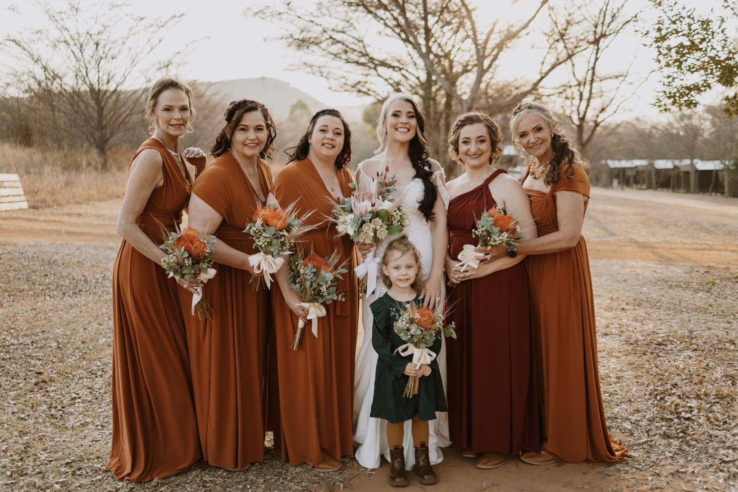 bridesmaid infinity wrap dress Thank you Andri Young sending your beautiful wedding photos. You and your bridesmaids look amazing . Bridesmaids wearing rust dresses made with love by Infinity Dresses handle