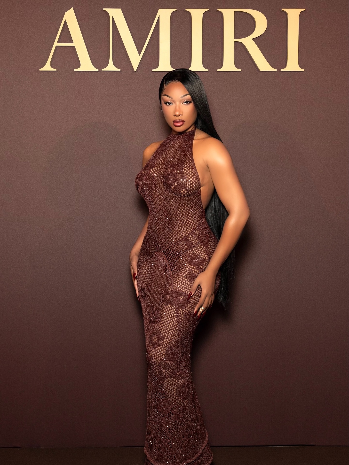 megan thee stallion gold dress showcased her bold fashion sense with two striking outfits recently, embodying the current trend of daring, high-fashion looks. In Milan, she wore a see-through, chocolate-brown knitted designed by WOMENS