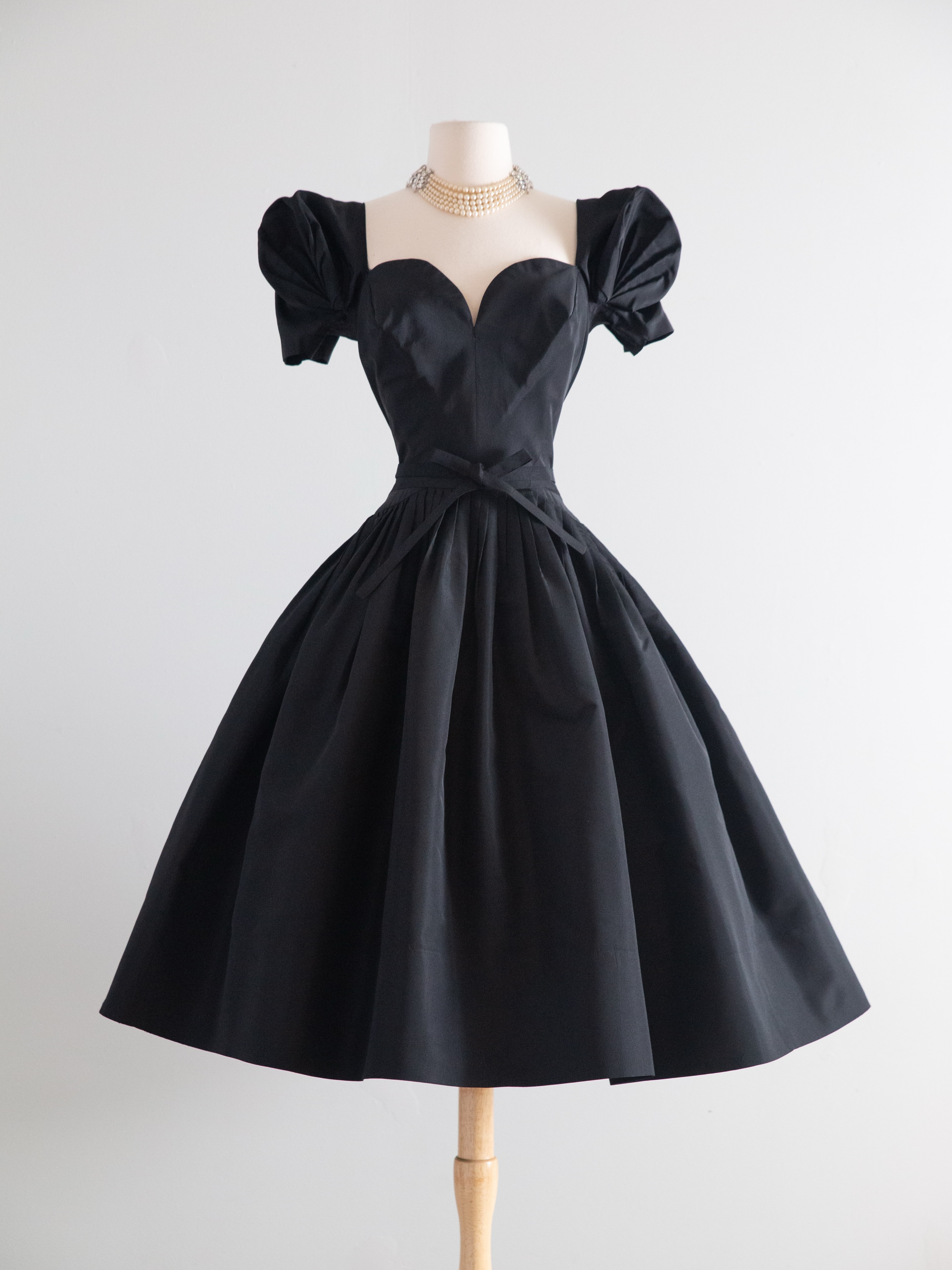 Who designed this 1950's black silk faille couture dress?