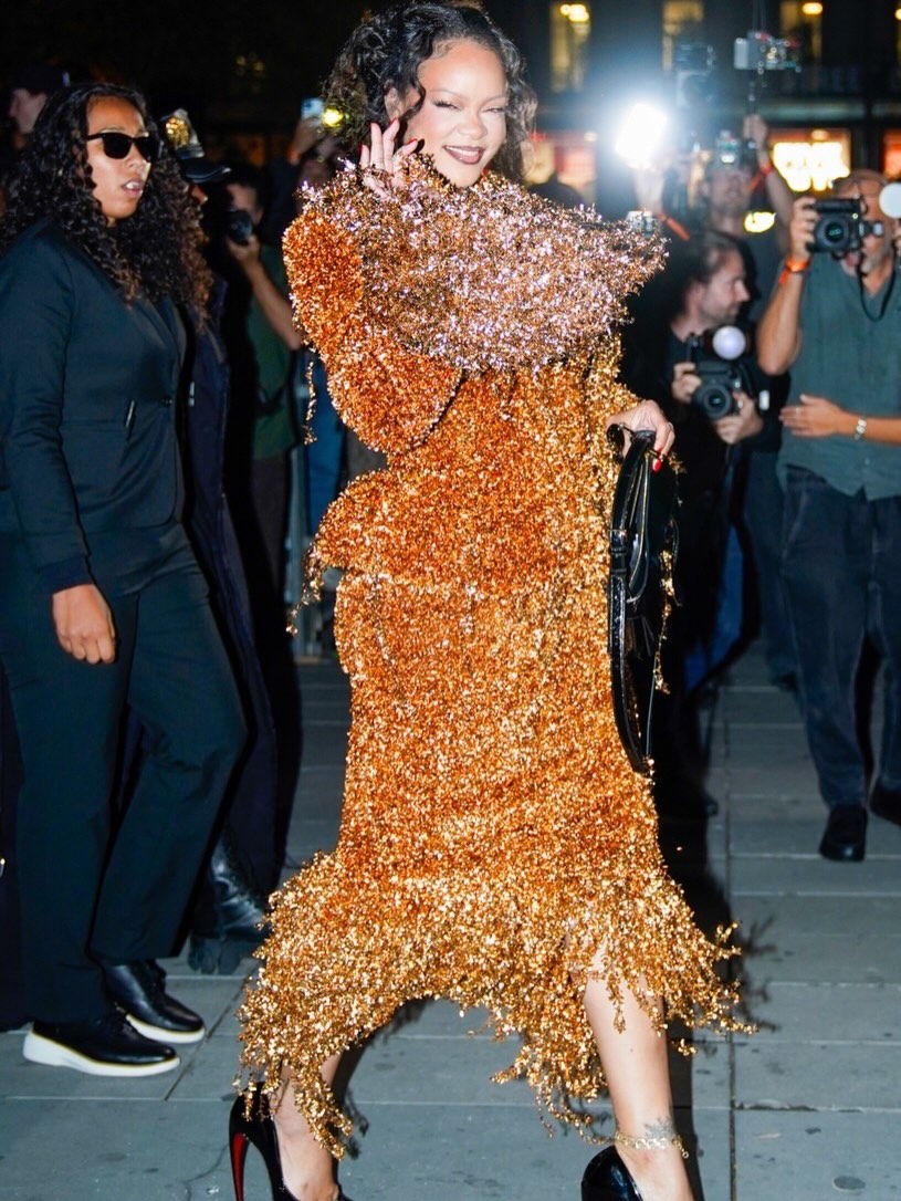 Rihanna is going for gold! The star stepped out in a dramatic gold skirt suit during Paris Fashion Week, pairing the look with black heels and a matching bag. #Rihanna #ParisFashionWeek Photos