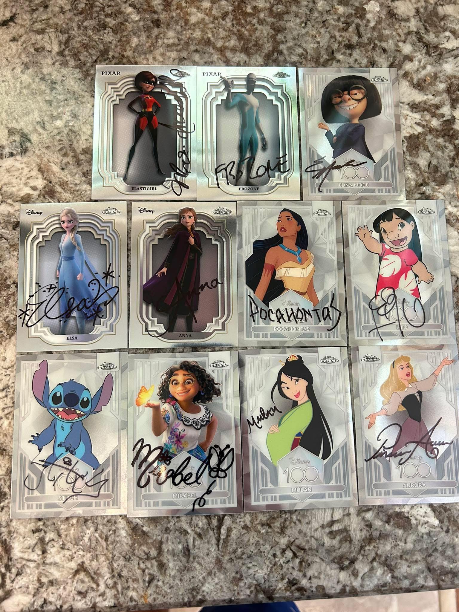 Signed Topps Disney cards with Aladdin and Mirabel