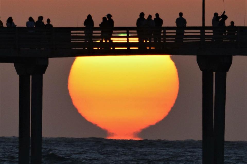 Green flash as see through the railing of theOcean Beach Pier .