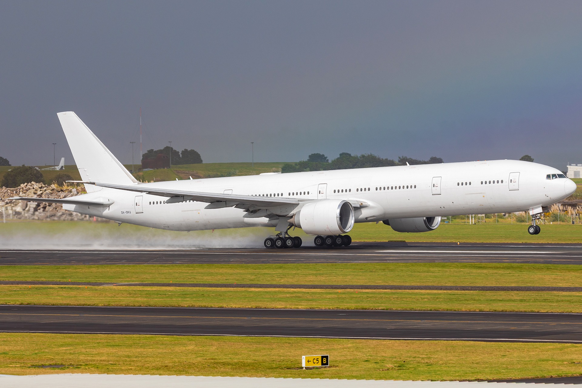 Boeing 777-300ER landing under a rainbow