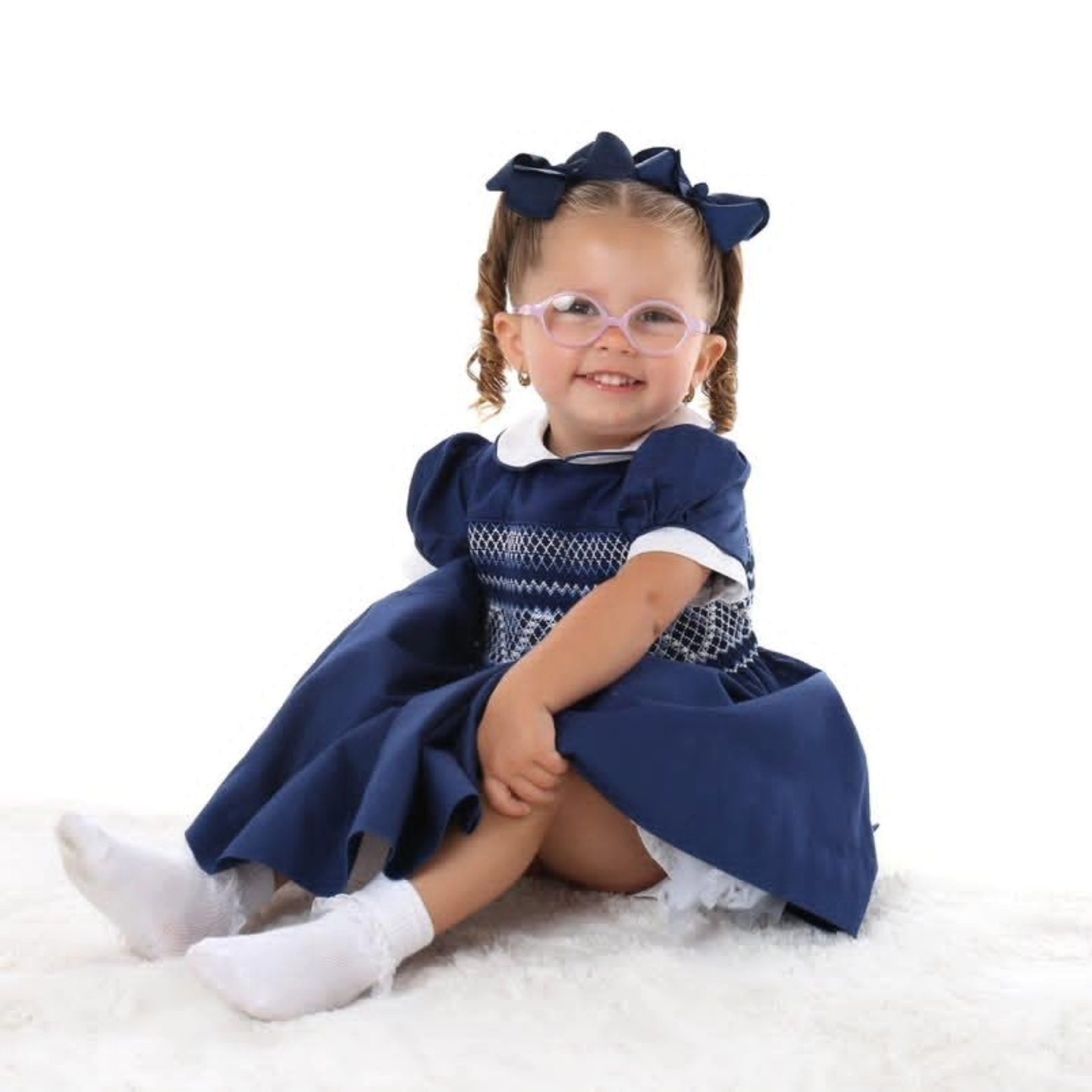Adorable little girl in classic navy smocked dress