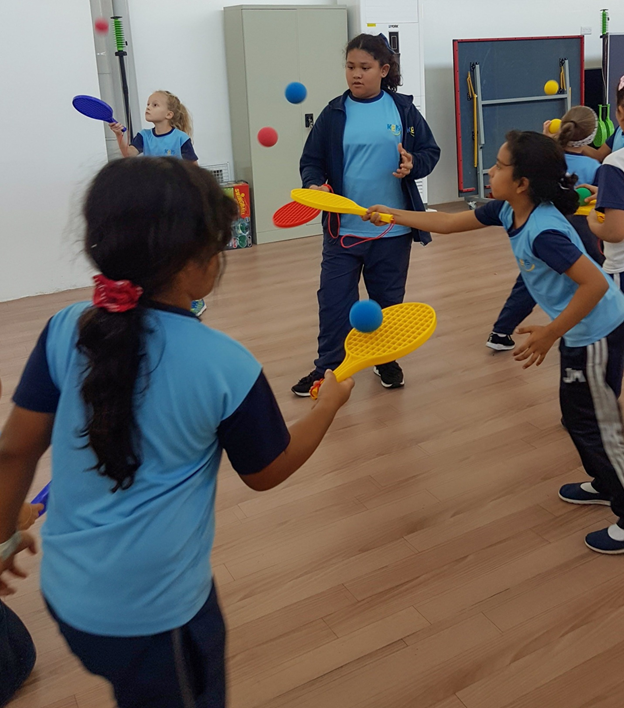 KGIS Oman - Grade 3 students learning racket skills in P....