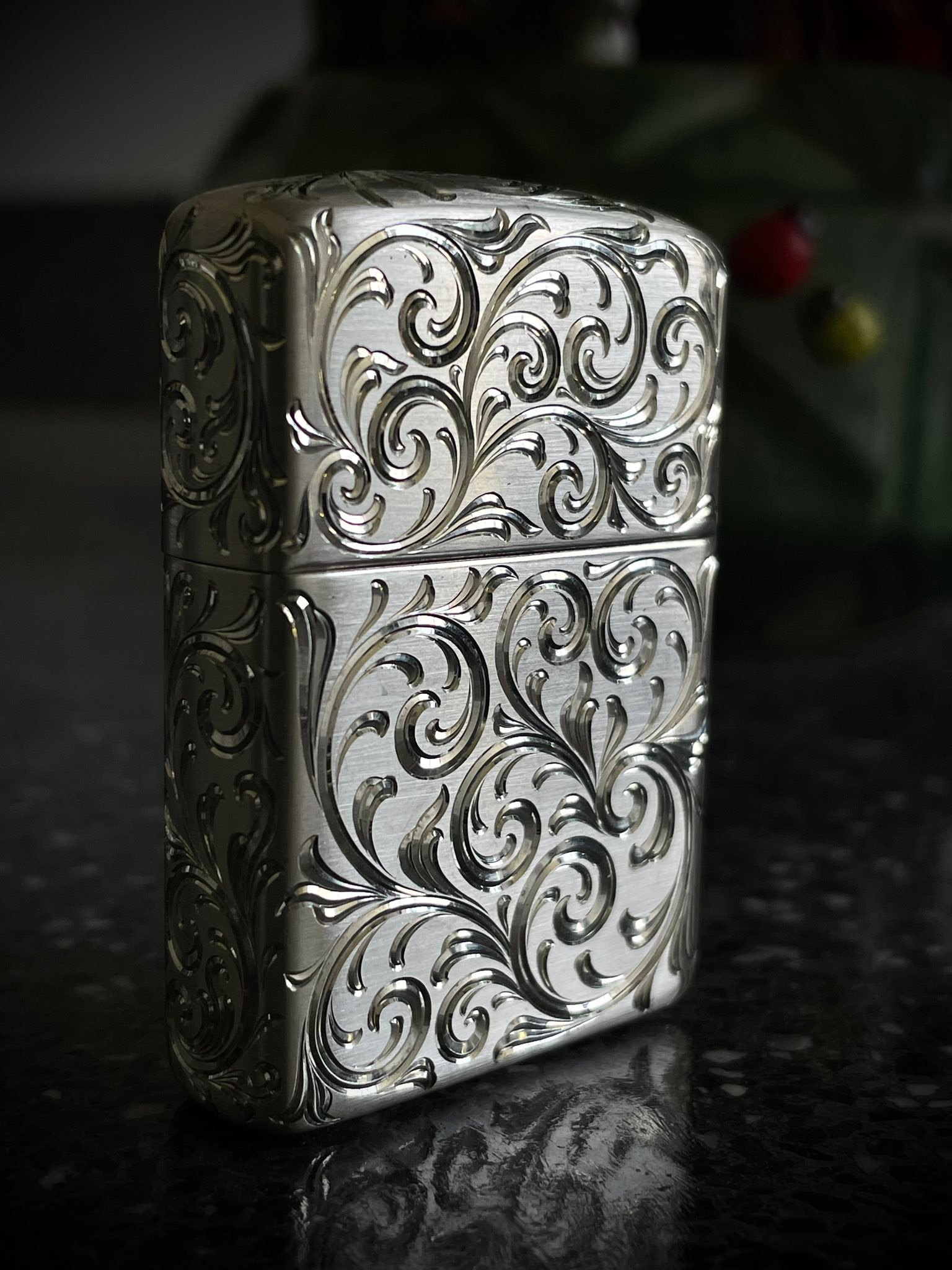 Hand-engraved silver Zippo lighter with scroll pattern
