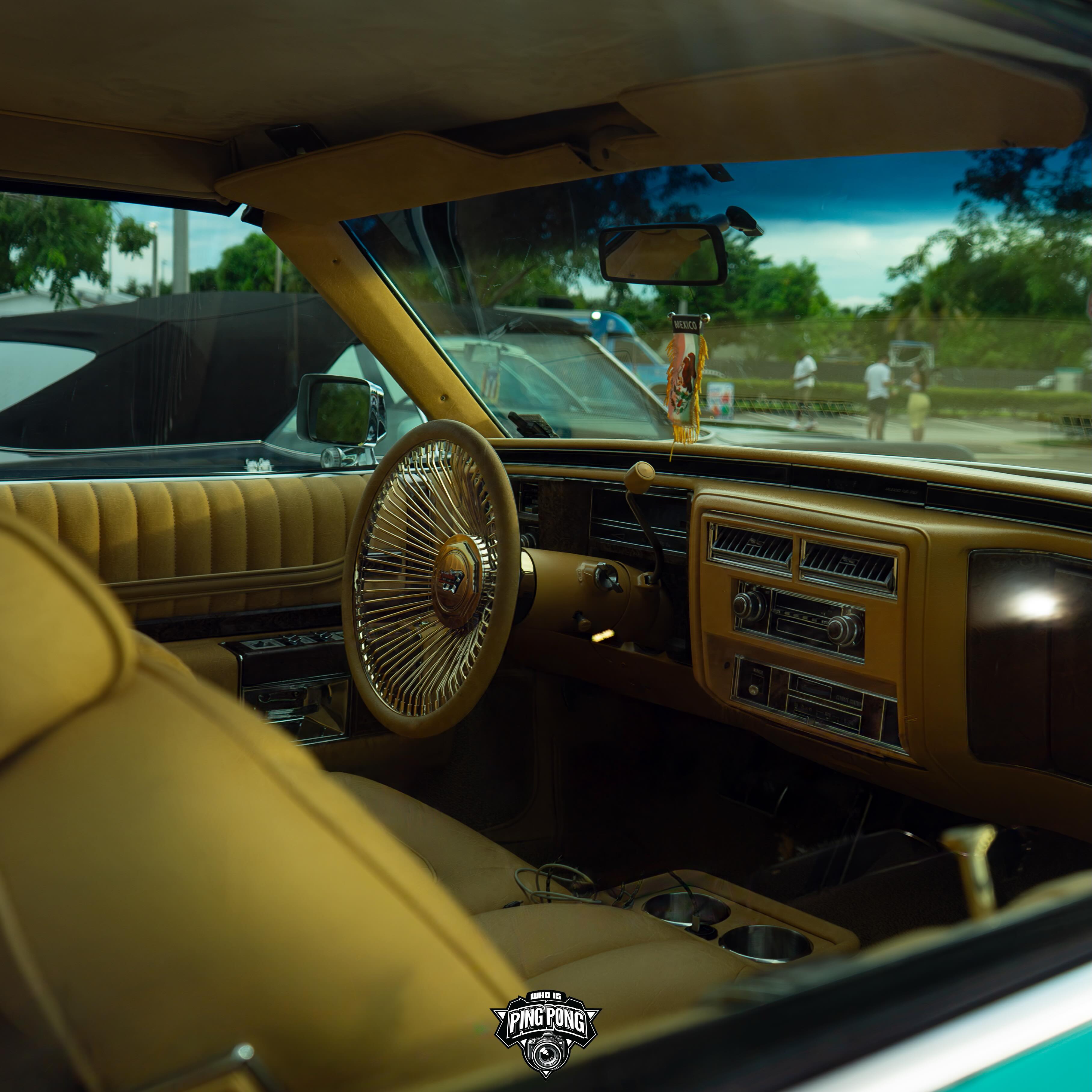 Teal Cadillac Le Cabriolet on gold Dayton wire wheels in Miami Gardens