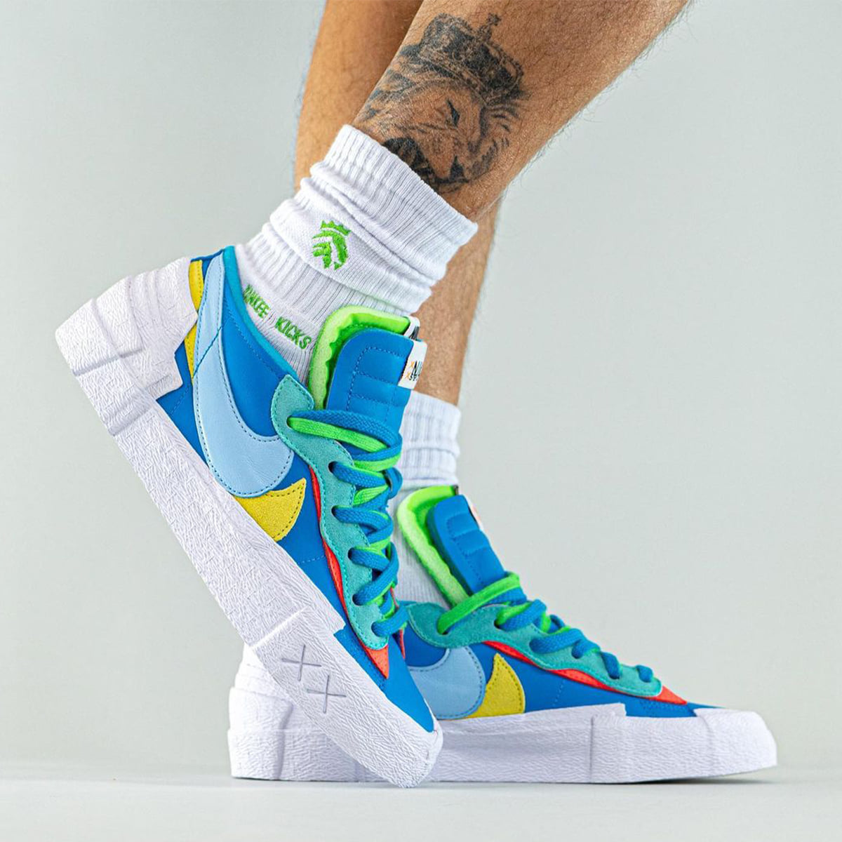 The “Neptune Blue” KAWS x sacai x Nike Blazer Lows drop in 