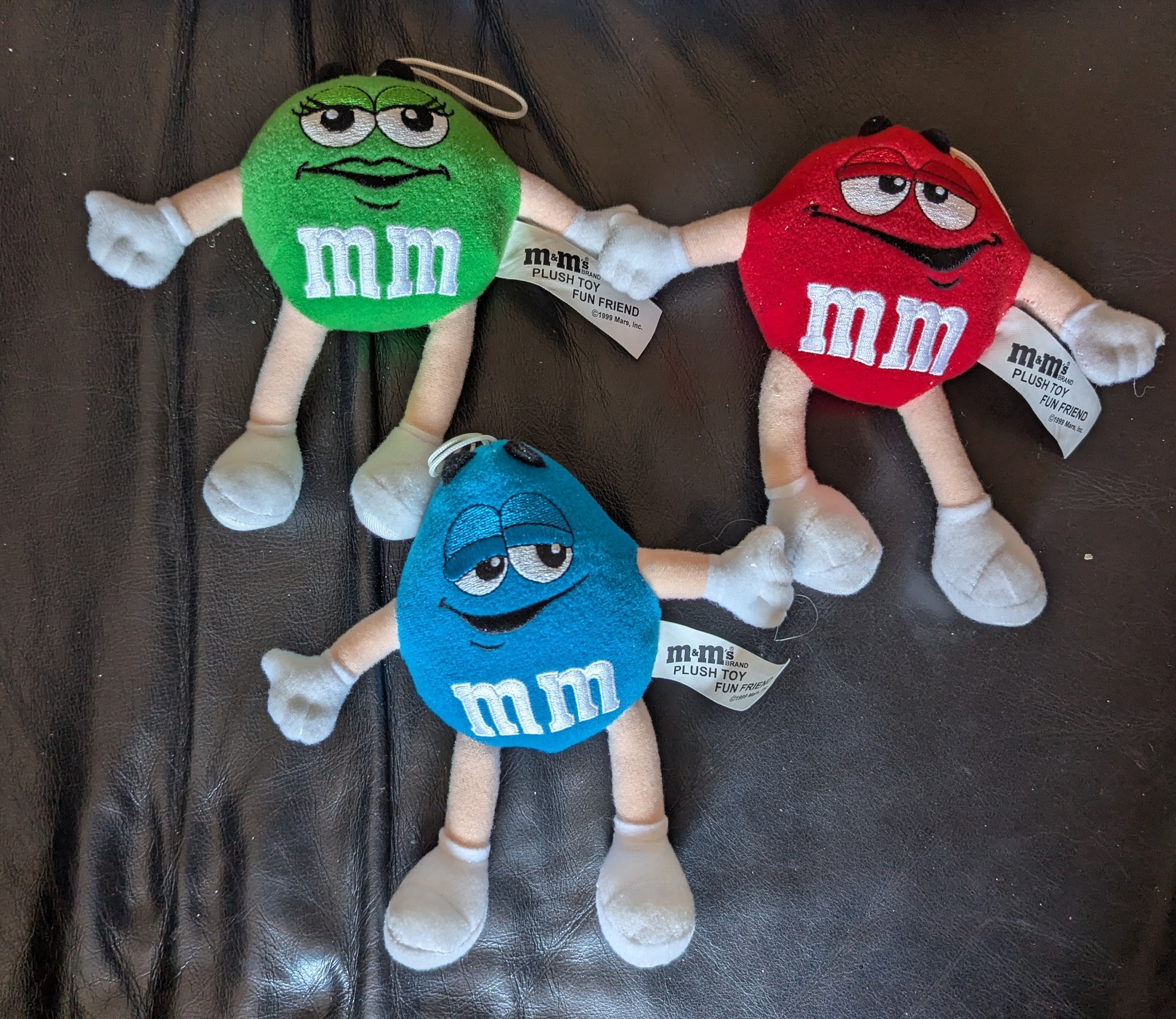 Soft plush M&M's character toys in green, yellow, red, and blue