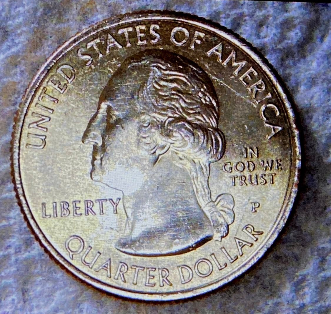 Hello I want to know if this 2018 P Apostle Island quarter that I believe is in low MS condition with 2 huge die chips on the reverse has any value?
