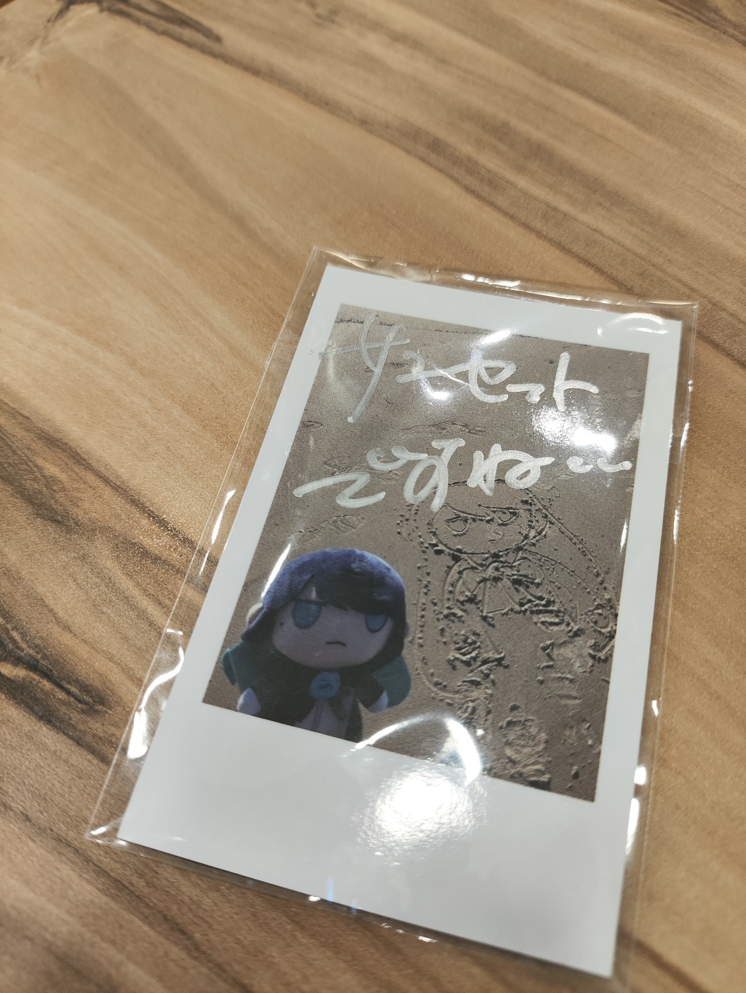 What is the translation of the signed text on the Ado trading card?