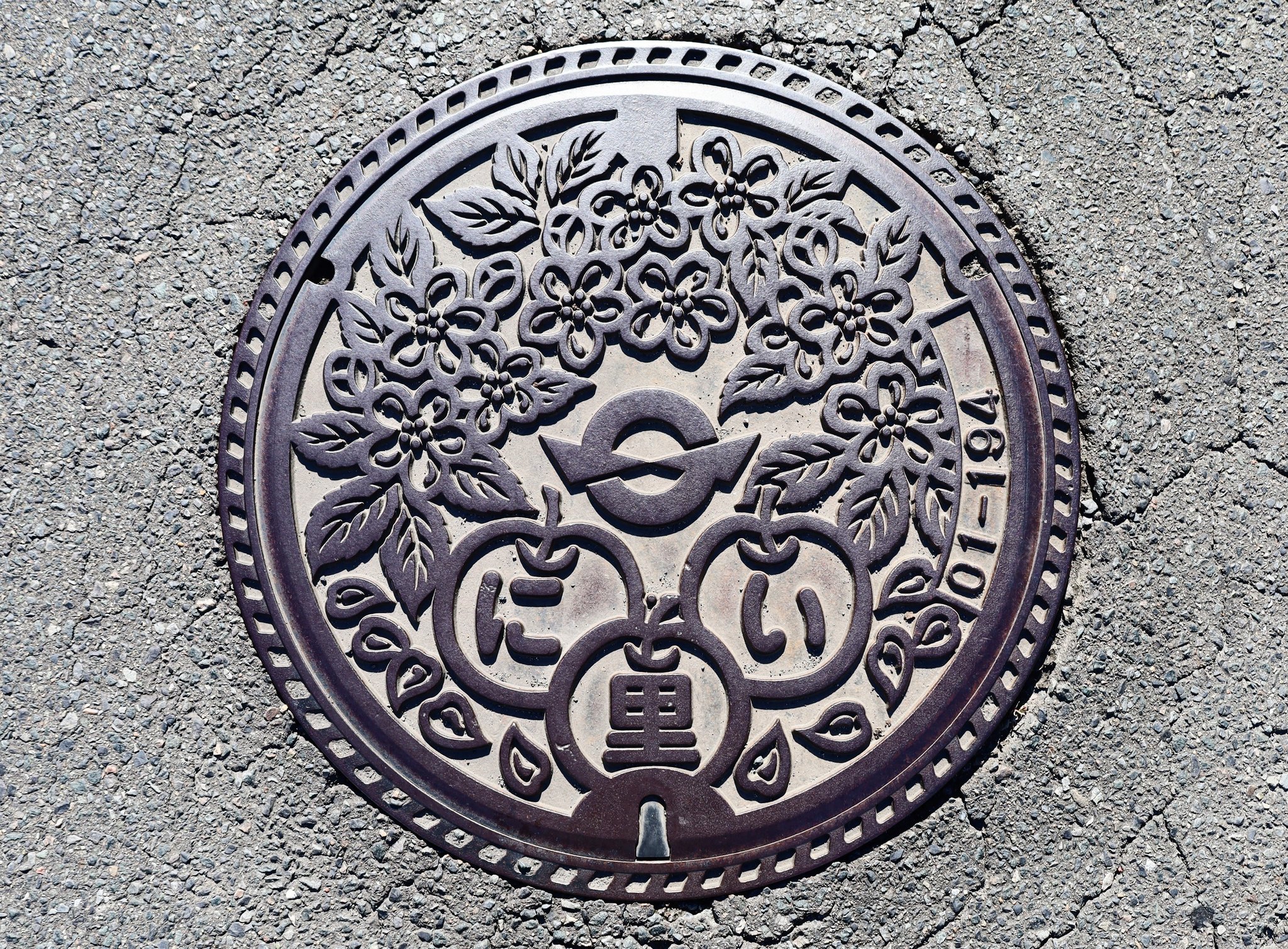 Yoshio - 旧新里村（現宮古市）のマンホール蓋 ノンカラー 中央に村章、リンゴの花とリンゴに「に・い・里」の表記。 蟇目（ひきめ）地区の ...