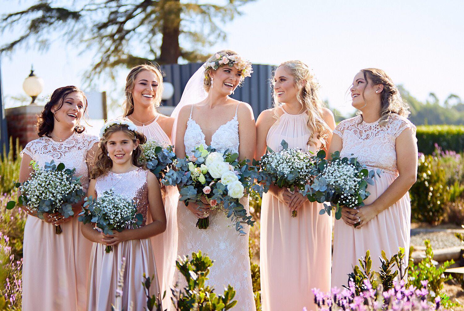 bridesmaid dress to compliment bride Hoiden Client ••• A Picture perfect wedding and bridal party, we love how the soft blush coloured bridesmaids dresses the setting. ••• Bridesmaids are wearing different catalogue styles all in the this maxi dress by newsizechart BHLDN Claudia Asymmetric Ruffle Color:Chambray