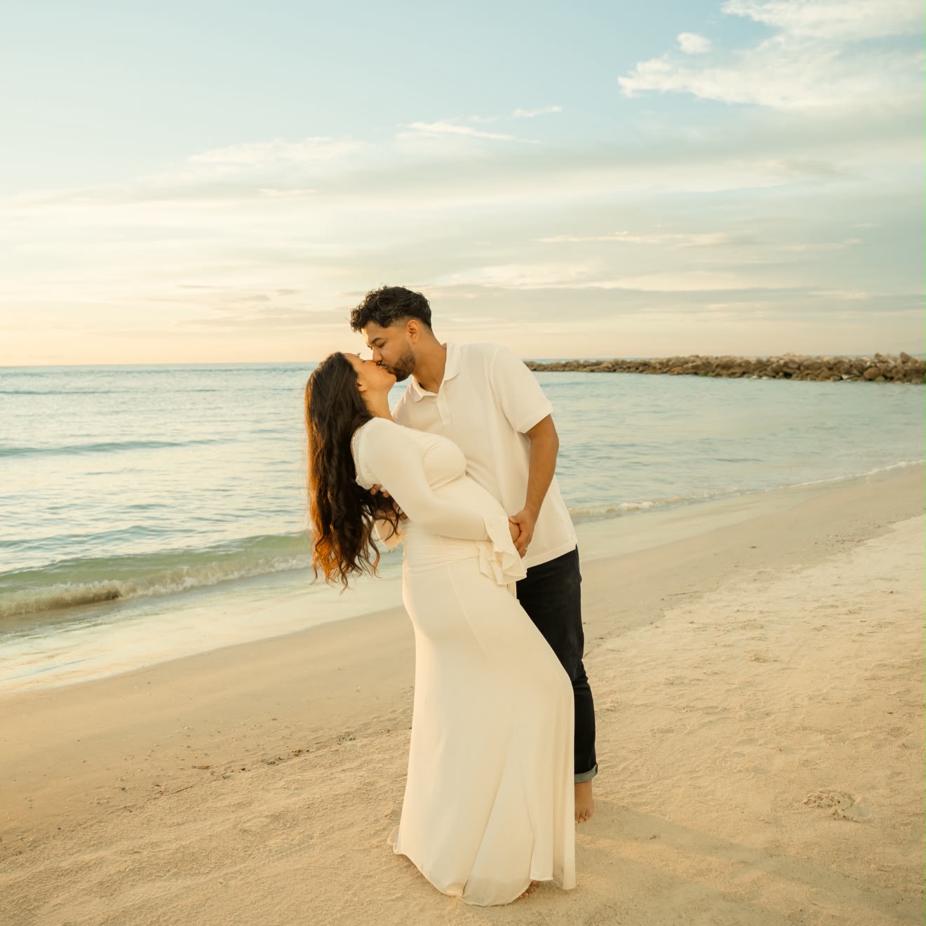 Maternity beach photoshoot with couple in white dress