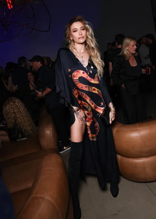Paris Jackson stole the spotlight at Universal Music Group's Grammys After Party! 🔥🐍 She rocked a bold black kaftan dress featuring a vibrant orange and red snake print with a daring thigh-high