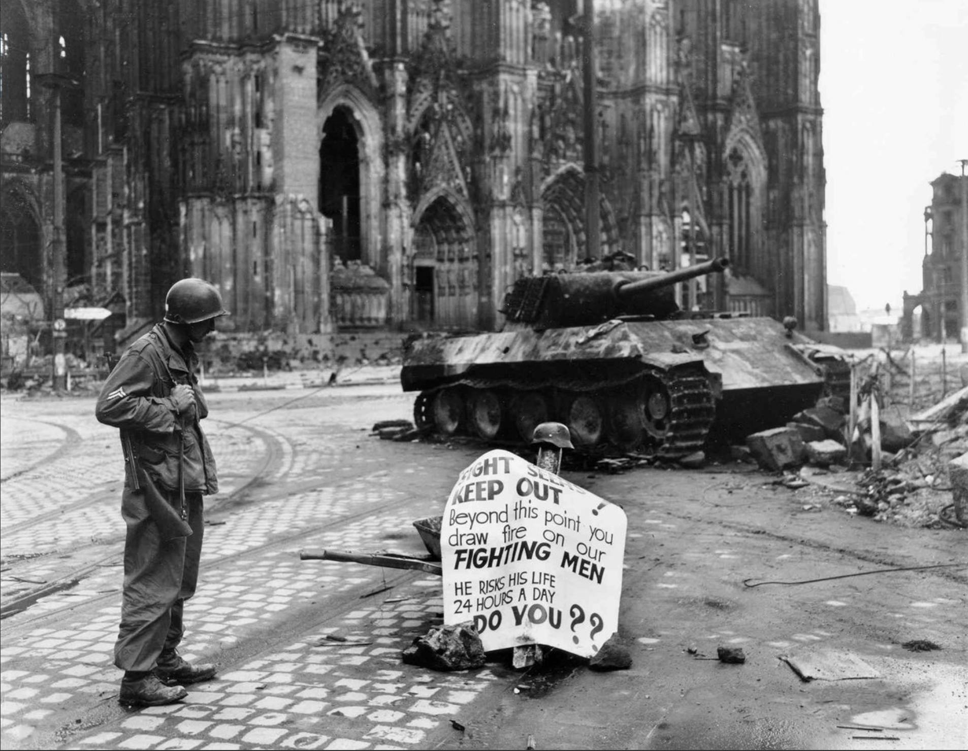World - US 3rd Armored personnel look at 90mm shell holes in a ...