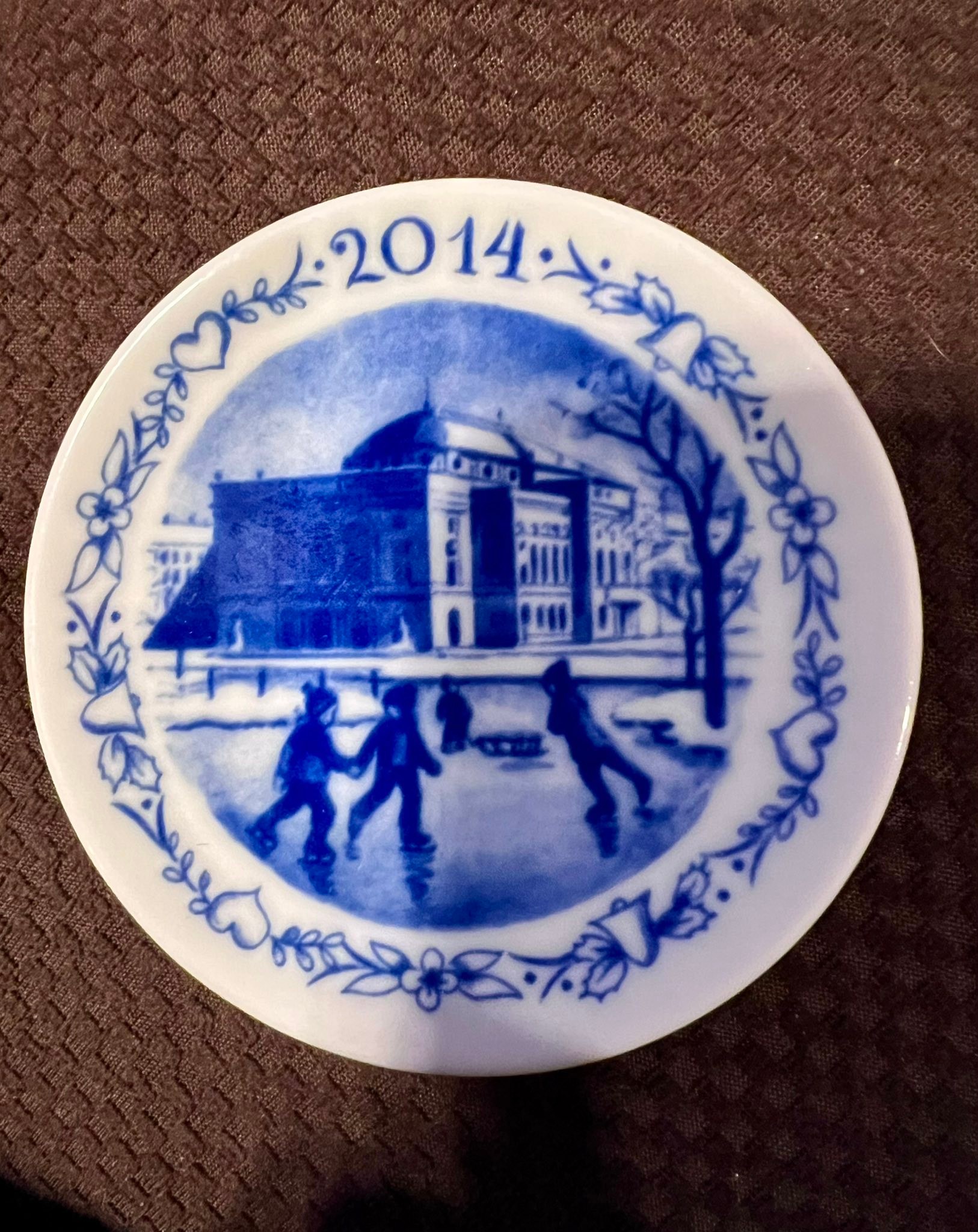 Collectible porcelain plate is blue and white. This hand-decorated 