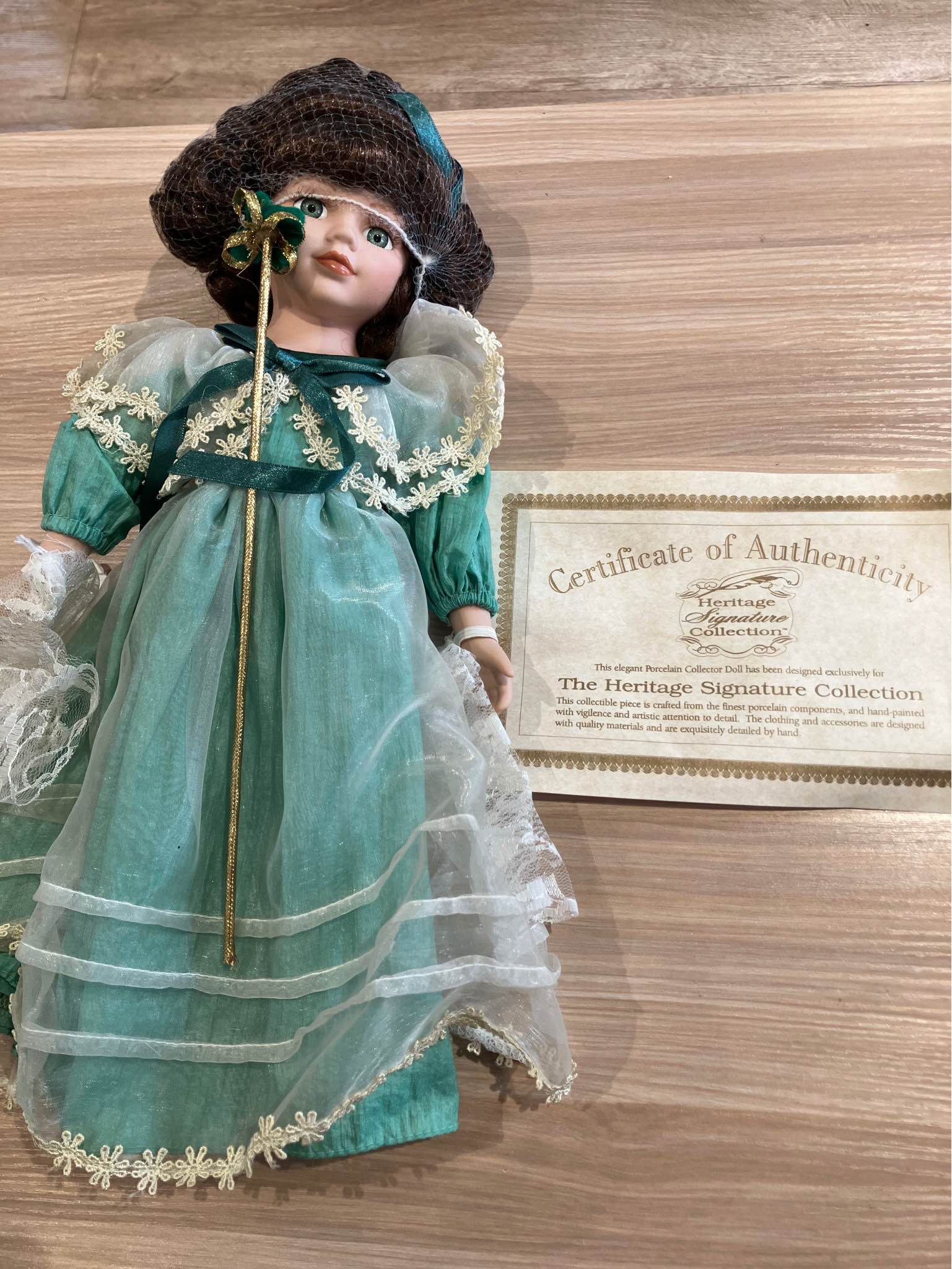 porcelain doll in green dress Elegant collector from the Heritage Signature Collection. This hand-painted piece has a with lace detailing and includes a certificate of authenticity. It comes its original branded box antique porcelain dolls